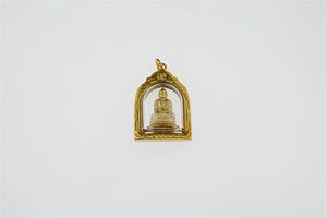 Detaillierte Makroansicht des vergoldeten Buddha-Anhängers mit Swastika-Symbol und Glaskuppel