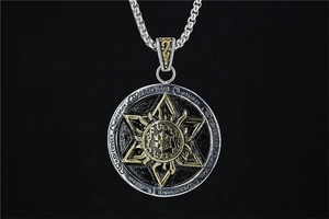 Macro detail of silver hexagram medallion pendant with gold sunburst and rune engravings
