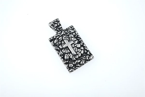 Détail du pendentif rectangulaire argenté avec texture martelée et motif de croix centrale