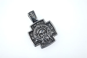 Macro detail of silver stainless steel cross pendant with embossed religious icon and engraving