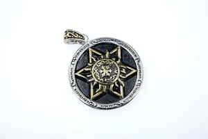 Detail of two-tone star pendant with religious runes and vintage textured finish