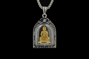 Makroaufnahme der goldenen Buddha-Statue im silbernen Anhänger mit Edelstahl-Kette