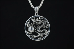 Macro shot of a vintage silver dragon pendant with detailed scales and pearl motif