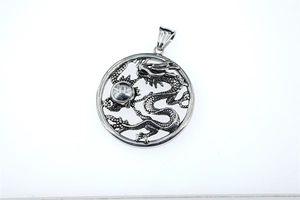 Macro detail of retro dragon relief on silver stainless steel pendant with bead