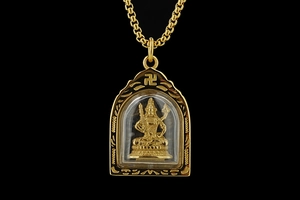 Detailansicht eines goldenen Buddha-Anhängers mit geometrischer Gravur und Box-Kette