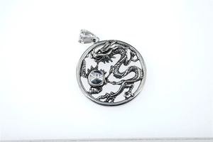 Detailed macro view of a silver dragon pendant featuring an intricate hollow design