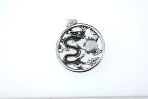 Macro detail of vintage dragon pendant with oxidized silver finish and intricate carving