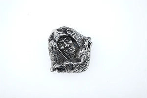 Detail of silver Nordic pendant featuring a bearded face and twin ravens engraving