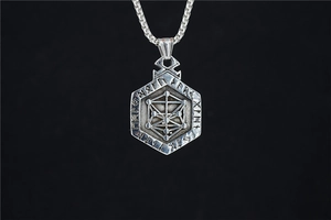 Macro detail of vintage silver hexagon Viking pendant with Nordic runes and steel chain