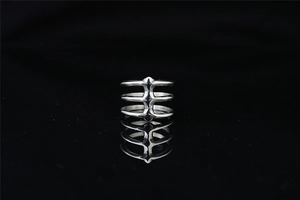Detailed view of silver spine-shaped ring with multi-layer industrial bone structure