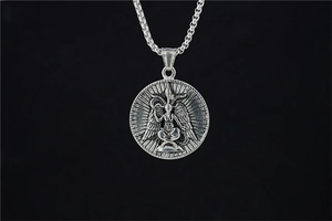 Macro shot of vintage silver Baphomet fallen angel circular pendant on a box chain link