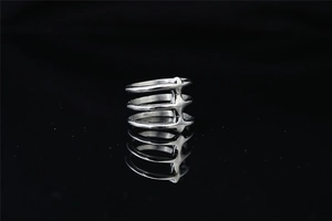 Macro detail of silver layered spine ring with industrial rivets and mirror reflection
