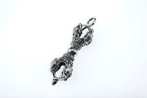 Macro shot of vintage silver Buddhist Vajra pendant with intricate religious relief details