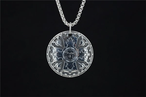 Macro detail of retro circular shield pendant with Psalm 28 7 engraving and cross symbol