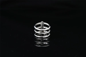 Macro detail of minimalist triple-layered silver steel ring on black reflective surface