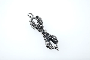 Detail view of vintage Vajra pestle pendant with retro textured finish and religious motifs