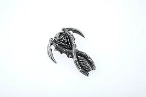 Close-up of vintage steel Grim Reaper pendant with skull and dual scythes detail