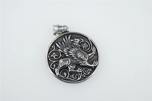 Détail macro du pendentif griffon rond avec relief vintage et décor de vigne argent