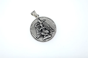 Macro shot of silver Baphomet fallen angel medallion with vintage texture