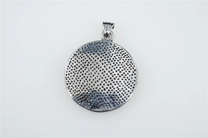 Détail macro de la structure alvéolée à l'arrière du pendentif en argent
