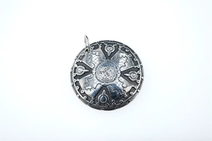 Macro view of retro round shield pendant with Psalm 28:7 engraving and cross texture