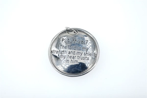 Detailed macro view of silver round cross shield pendant with engraved Bible Psalm 28:7 text