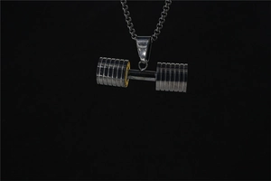 Macro shot of silver dumbbell pendant with detailed texture on a black background