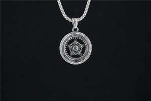 Macro detail of retro silver hollow wheel necklace with star and floral pendant
