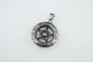Detail of vintage silver titanium steel tire pendant with industrial gear patterns