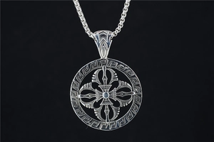 Detail of vintage silver titanium steel pendant with engraved cross and Greek fret pattern
