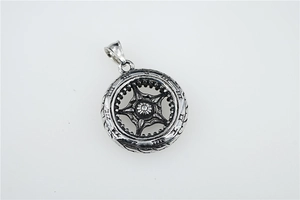 Detailed macro view of vintage titanium steel tire pendant with intricate carvings