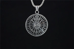 Détail du pendentif boussole vintage avec chiffres gravés et fleur de lys en métal