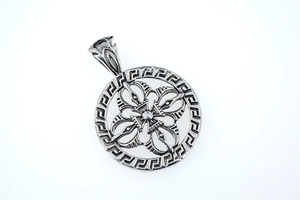 Macro shot of vintage silver steel pendant with cross crest and Greek fret pattern