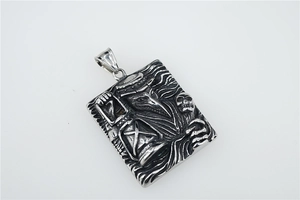 Detail of gothic plague doctor relief pendant with skull and hourglass on metal surface