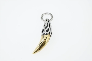 Detail of a punk style stainless steel wolf tooth pendant with silver floral engraving