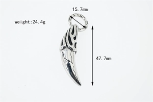 Macro detail of vintage stainless steel wolf tooth pendant with flame engraving and cracks
