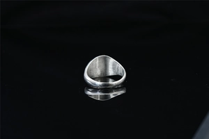 Vue arrière d'une bague chevalière en acier titane poli avec anneau épais sur fond noir