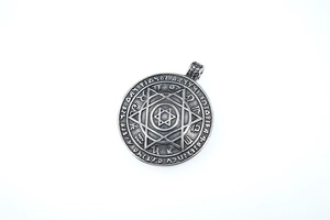Macro view of vintage Norse Viking heptagram and zodiac signs on round pendant