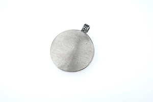 Macro shot of silver Nordic Viking medallion with vintage brushed texture and ornate bail