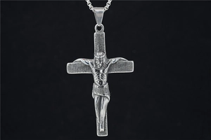 Macro detail of vintage silver titanium steel crucifix pendant with 3D Jesus relief