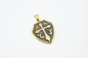 Detailed macro view of a golden stainless steel shield pendant featuring a raised cross design
