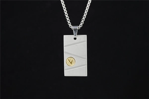 Vue détaillée du pendentif rectangulaire argenté avec rainures et emblème V doré