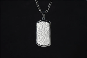 Détail du pendentif rectangulaire martelé avec de petits diamants et chaîne à boîte