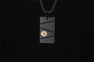 Détail du pendentif en acier titane noir mat avec rainures et insert doré décoratif