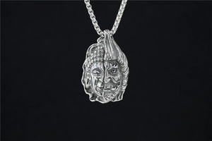 Vue macro du pendentif Bouddha et Démon avec gravures rétro détaillées en acier inox