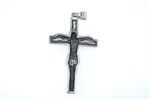 Detailed view of silver crucifix pendant with relief of Jesus on black oxidized steel
