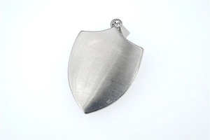 Detailed view of shield-shaped stainless steel pendant with brushed metallic finish