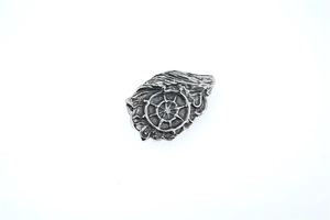 Détail du pendentif vintage argenté avec roue du dharma et textures d'ailes ciselées