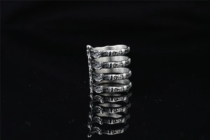 Macro view of Gothic 3D ribcage spine ring in silver-toned steel with mirror reflection