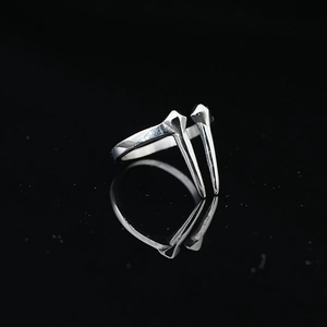 Anillo punk de acero de titanio con diseño de diente plateado sobre fondo negro